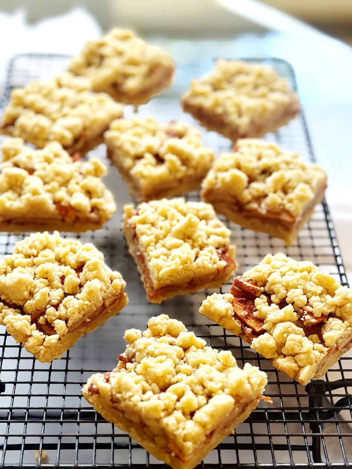 Apple shortbread bars sliced into squares on a cooling rack.