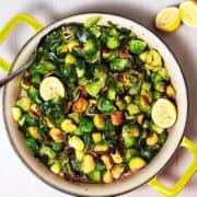 Brussels sprouts cooked up in a pan with lemon.