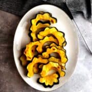 Roasted acorn squash slices on a plate.