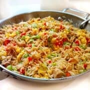 Fried rice with leftover pork in a large pan.