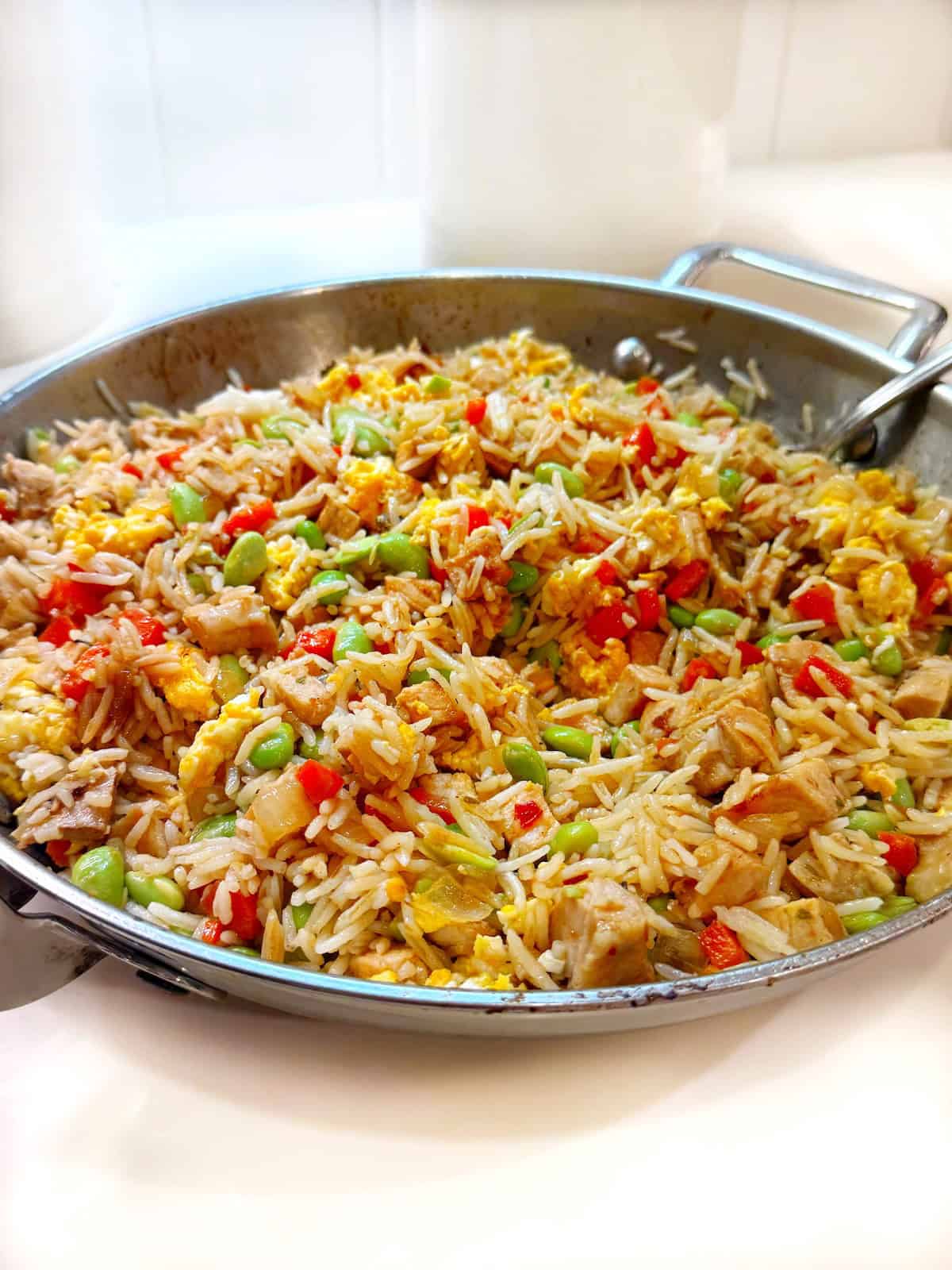 Fried rice with leftover pork in a large pan.