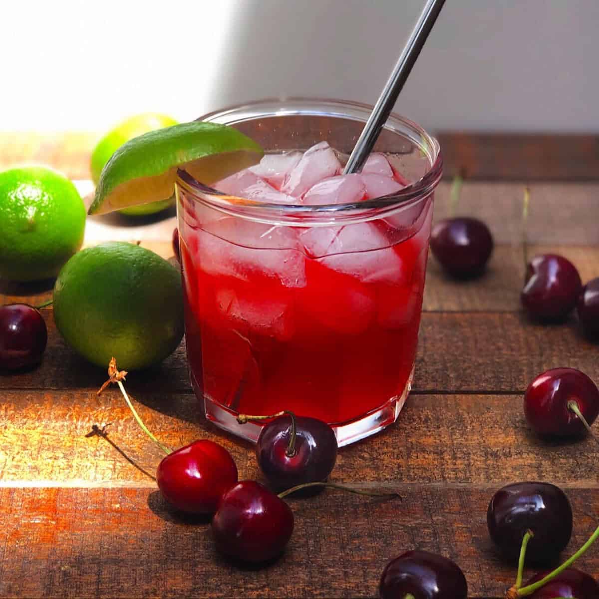 Homemade cherry limeade in a glass with ice.